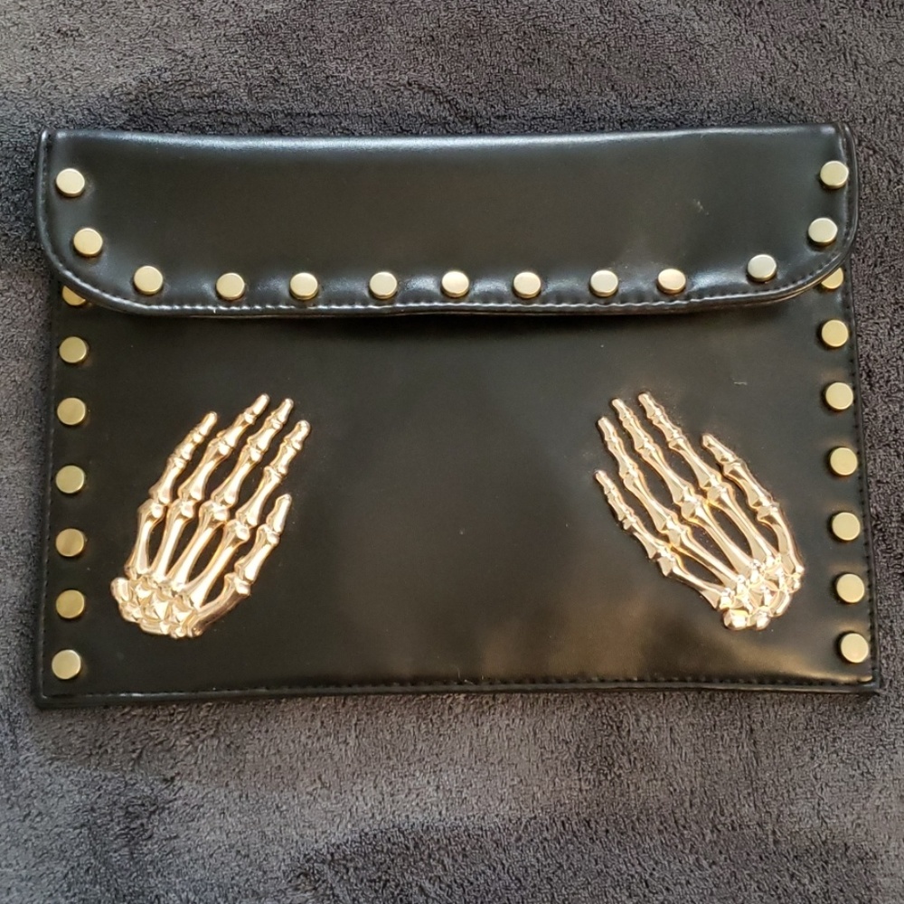 Black purse with gold skeleton hands